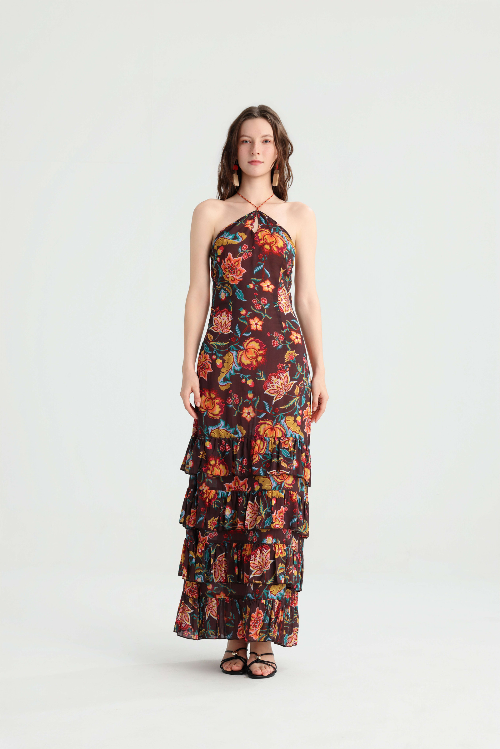 Full-length front view of the floral halter maxi dress styled with black strappy sandals