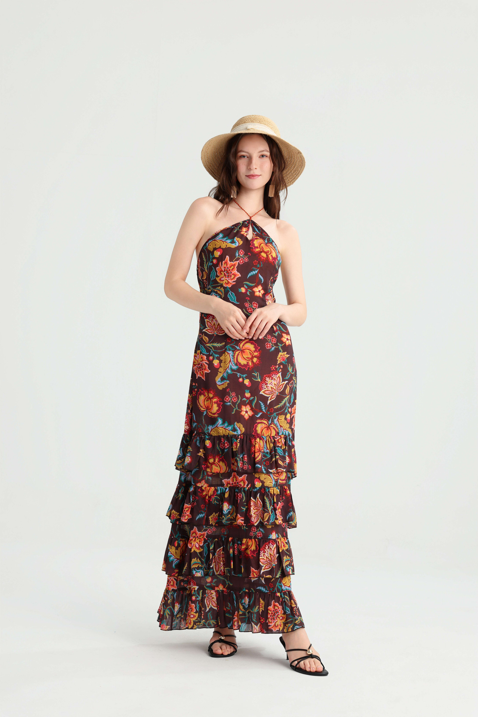 Front view of the floral ruffle maxi dress styled with a straw hat, hands held at the waist