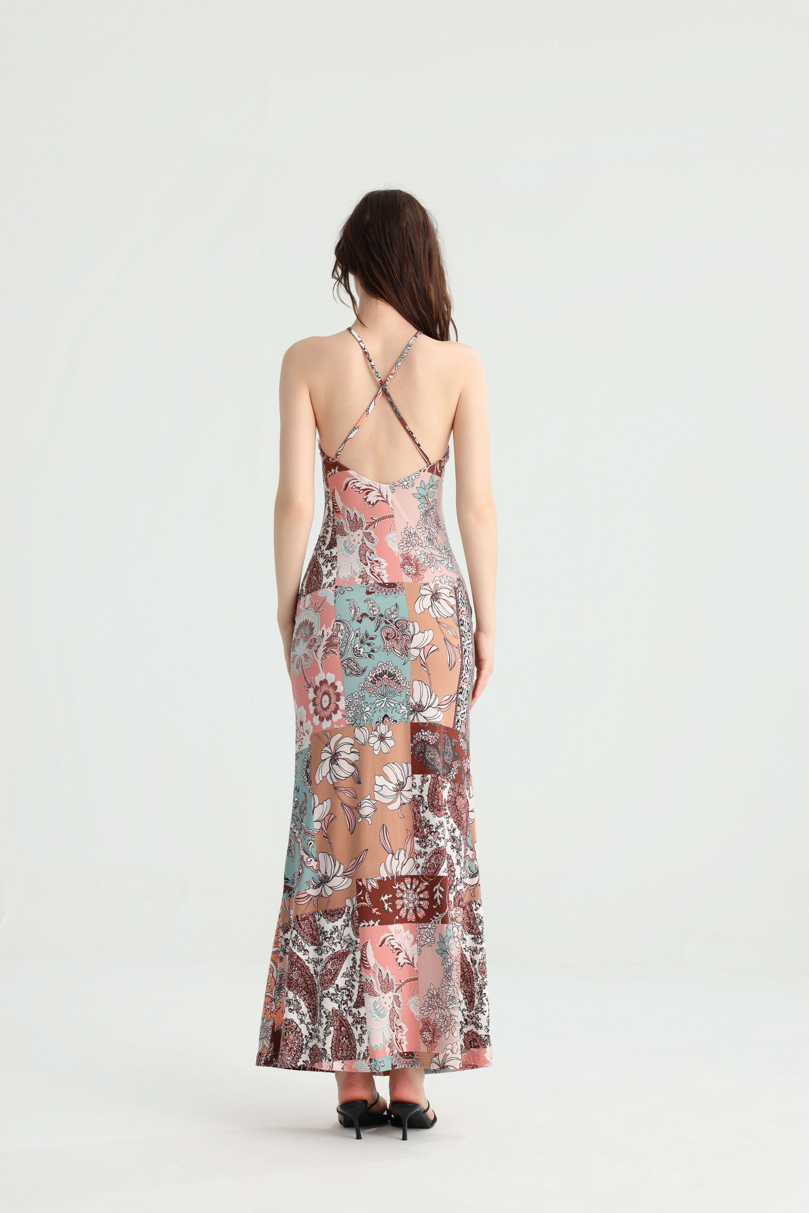 Back view of the patchwork halter maxi dress showing crossed straps, an open back and a mermaid hem