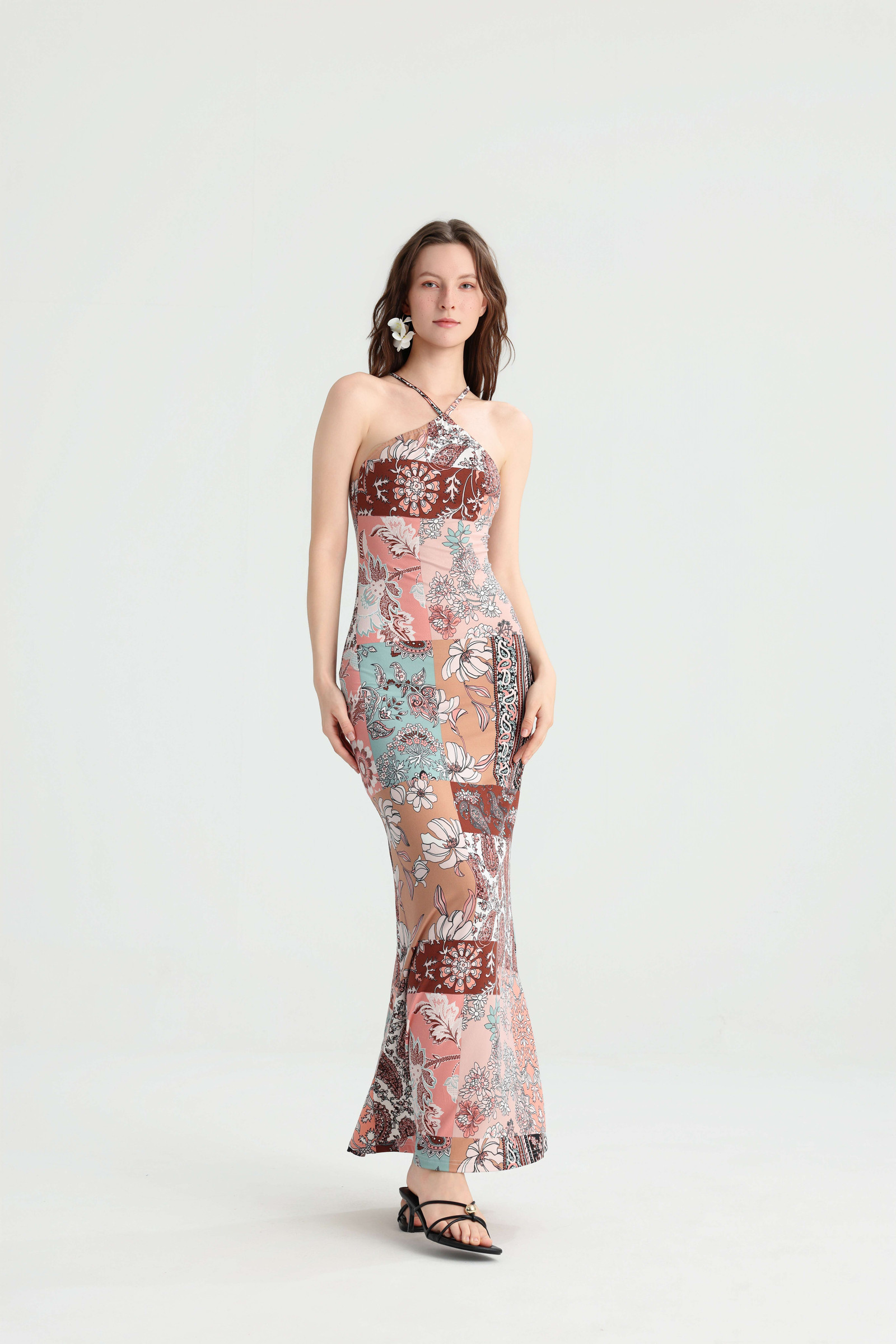 Model standing with one foot forward in the fitted pink patchwork maxi dress