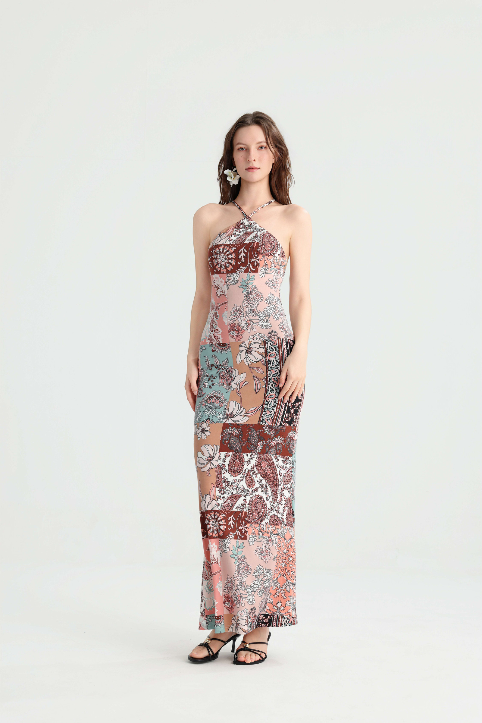 Front view of a pink patchwork halter maxi dress with mixed floral prints and a gently flared hem