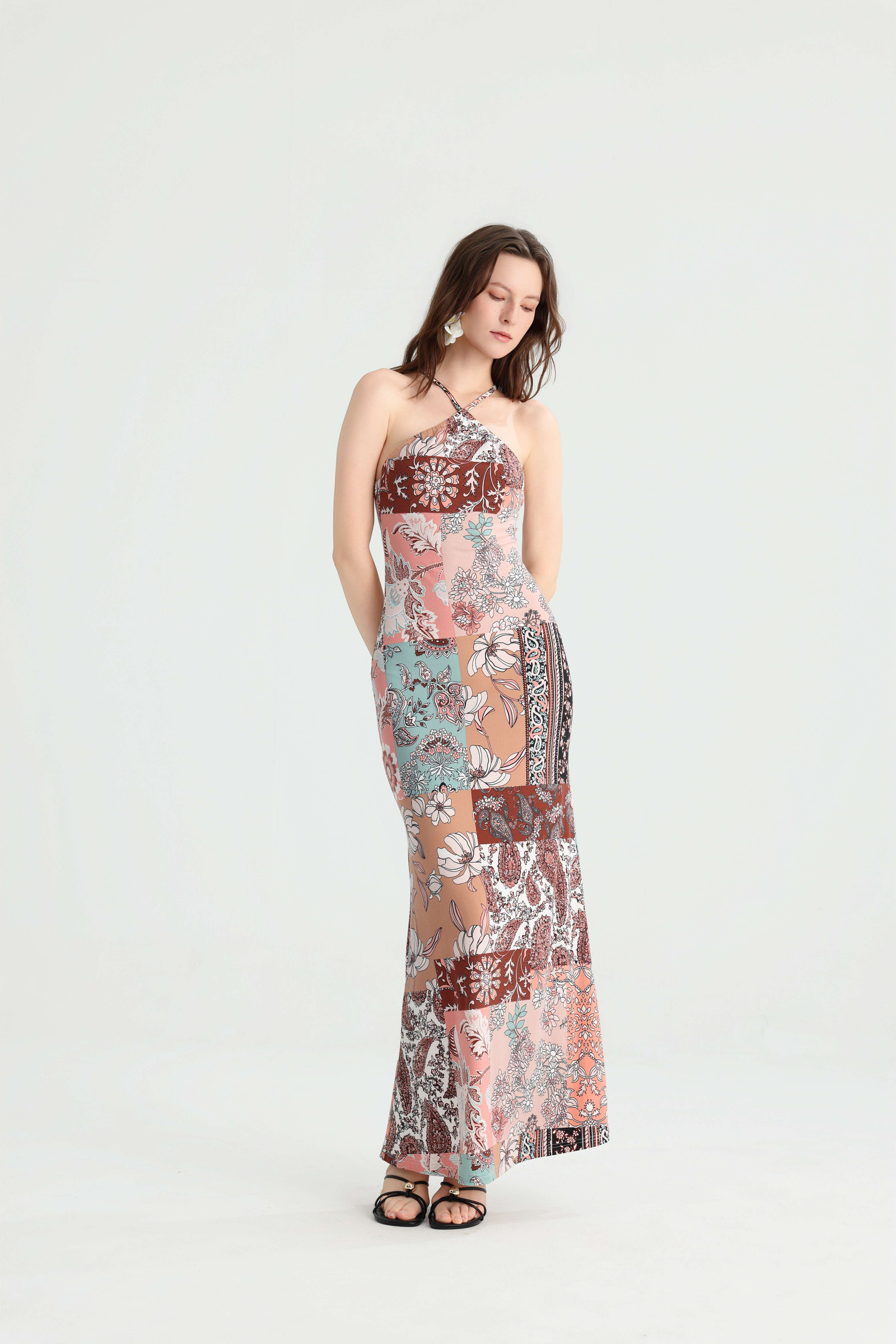 Model looking down while wearing the multicolor patchwork dress with a softly flared hem